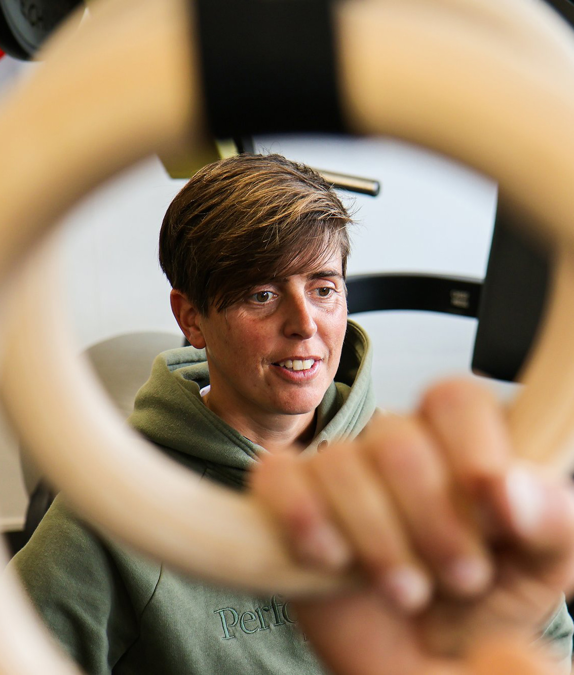 Clara Hamstra kijkt mee terwijl een client aan de ringen traint